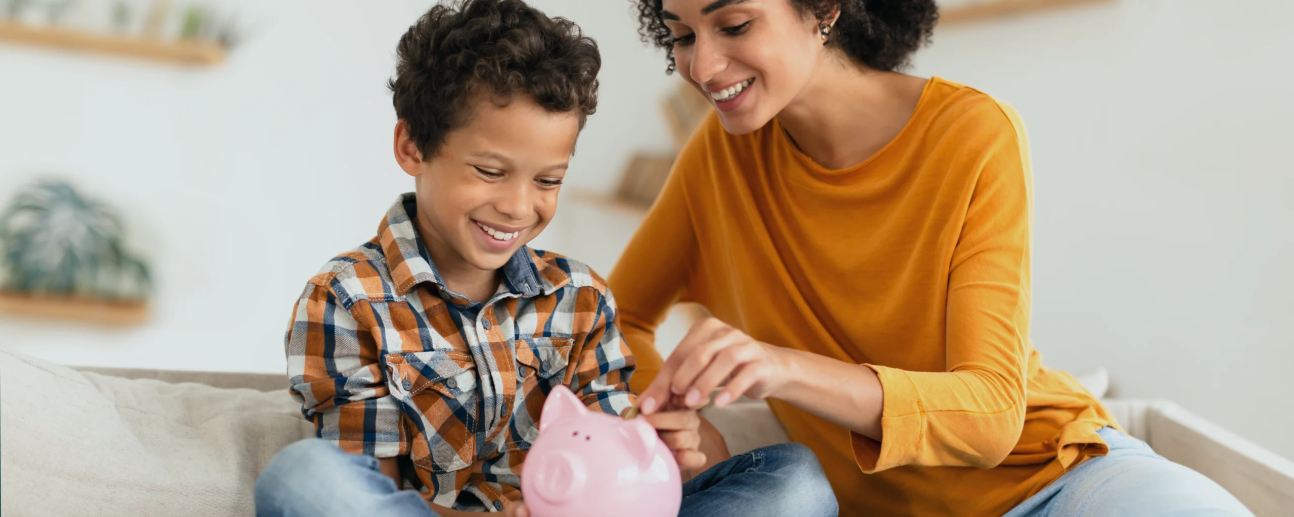 Une mère et son enfant qui mettent de l'argent de poche dans une tirelire.