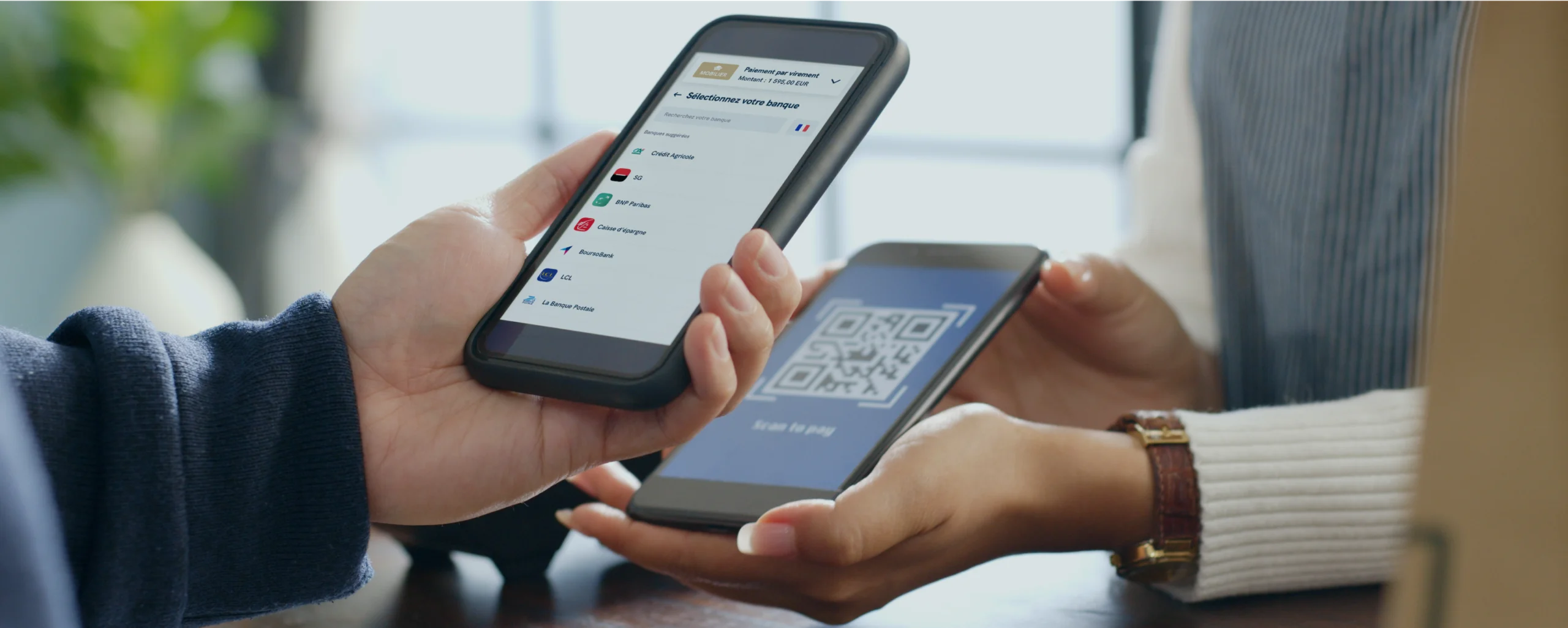 Deux personnes qui utilisent leurs téléphones pour faire un virement par QR code au lieu d'un chèque.