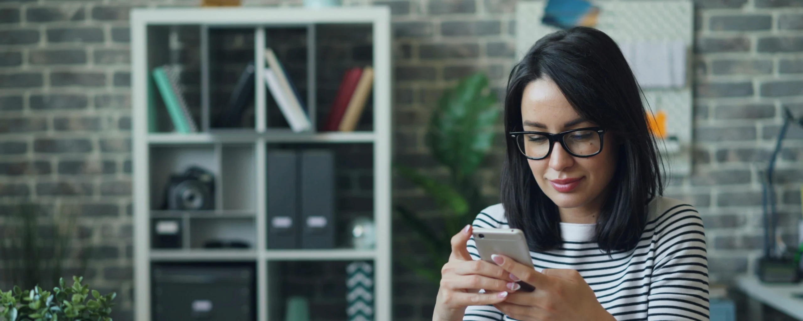 Femme qui scroll sur son téléphone pour faire un virement open banking.