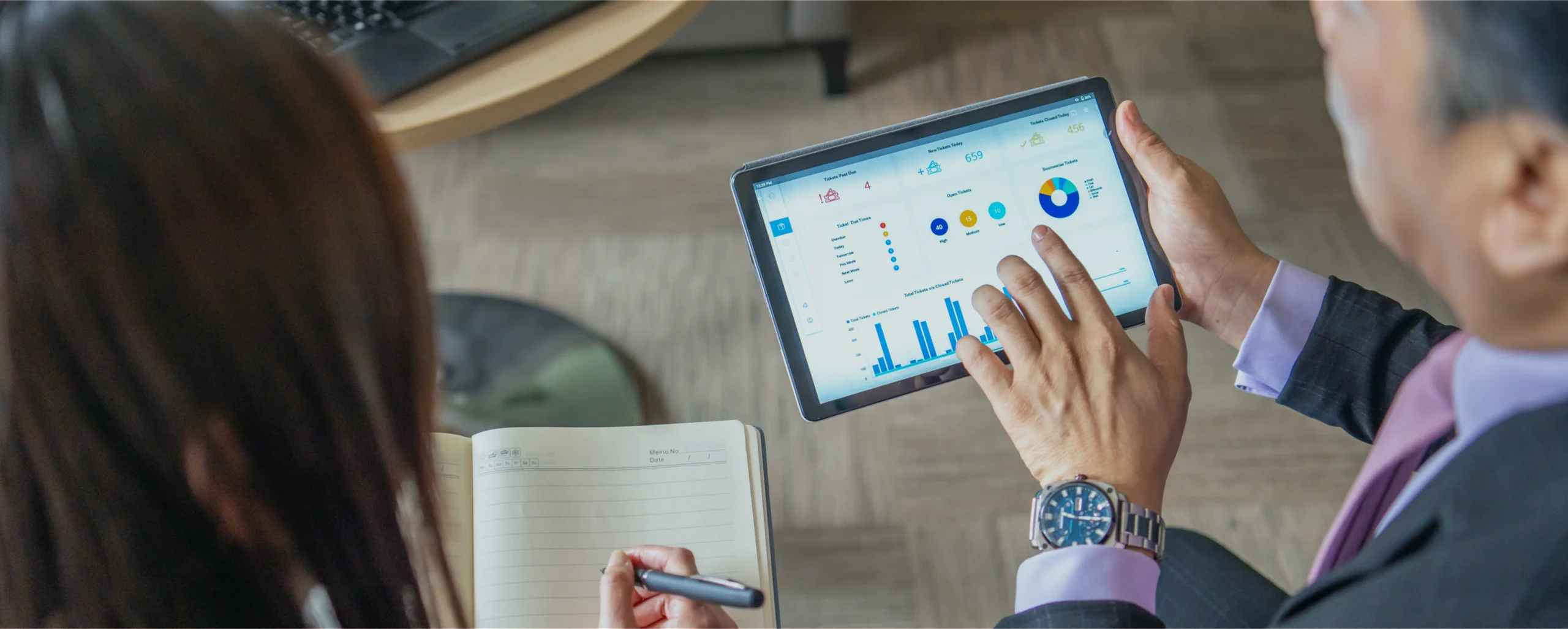 Personnes qui discutent de l'Open Finance en analysant une dashboard liée aux livrets d’épargne, les assurances-vie, les PEA, et tout autre produit financier.